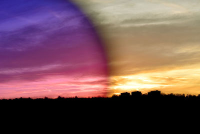 Silhouette landscape against dramatic sky during sunset