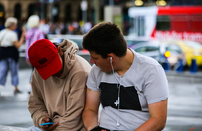 People sitting on street in city