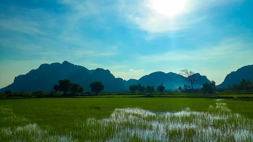 Scenic view of lake by mountains against sky