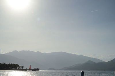 Scenic view of sea and mountains against sky