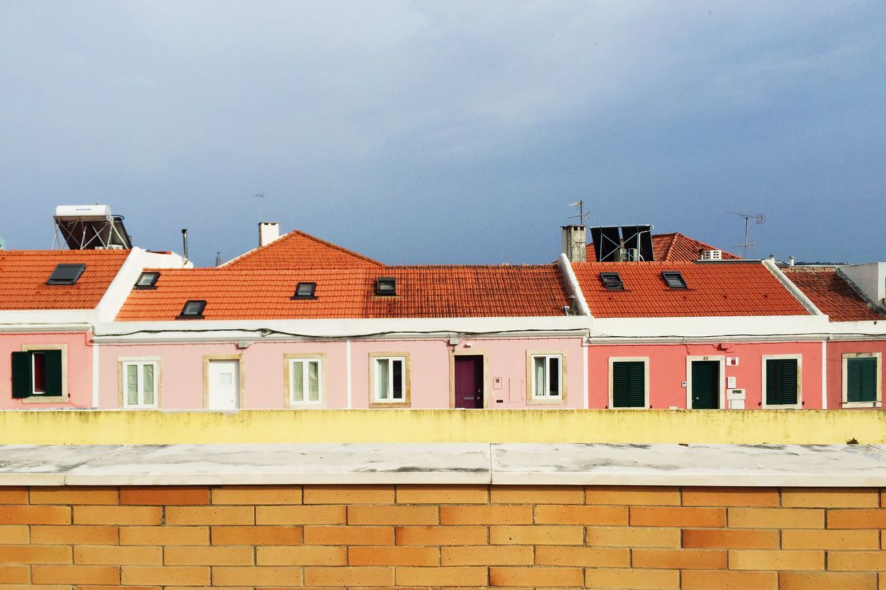 building exterior, architecture, built structure, window, low angle view, sky, building, residential building, residential structure, day, outdoors, exterior, city, no people, house, clear sky, high section, side by side, cloud - sky, cloud