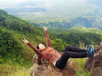 High angle view of young woman lying on mountain