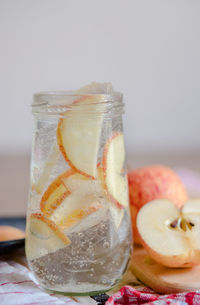 Close-up of drink with apple slices in mason jar on table