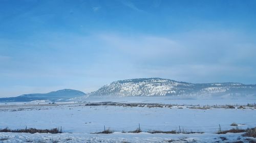 Scenic view of snowcapped mountains against blue sky