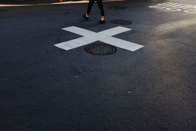 Low section of woman walking on road