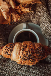 A cup of black morning coffee with a chocolate croissant. delicious meal. aesthetics in details.