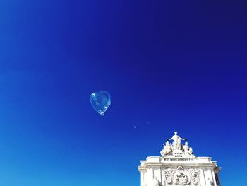 Low angle view of bubble in mid-air against triumphal arch