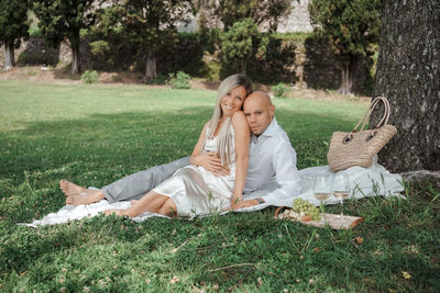 Young woman with young man sitting on field