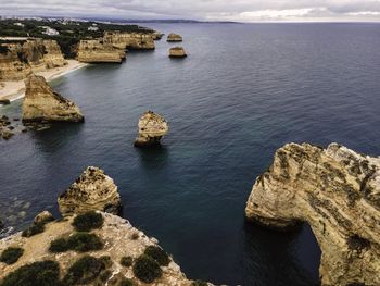 High angle view of rock formation in sea against sky