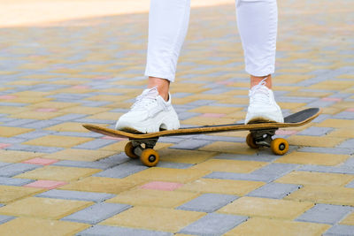 Low section of man skateboarding on street