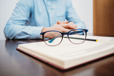 Close-up of man reading book on table