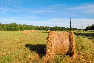 Hay bales on field against sky