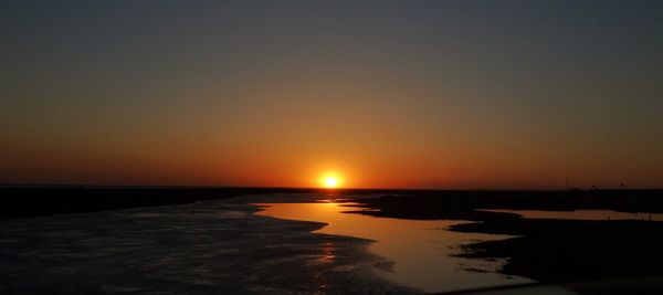 Scenic view of sea against orange sky