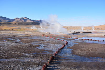 Scenic view of hot spring against sky