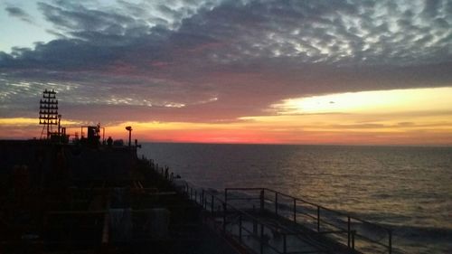 Pier on sea at sunset