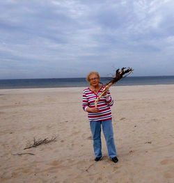 Boy standing on beach against sea
