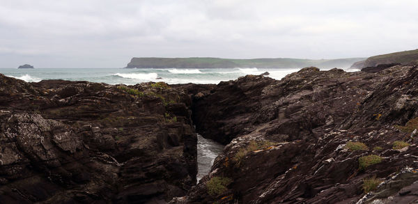 Scenic view of sea and cliff against sky