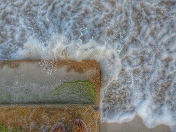 High angle view of waves splashing on beach