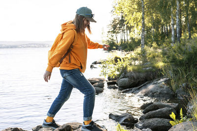 Side view of young woman standing on rock