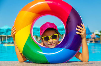 Portrait of smiling girl looking through inflatable ring