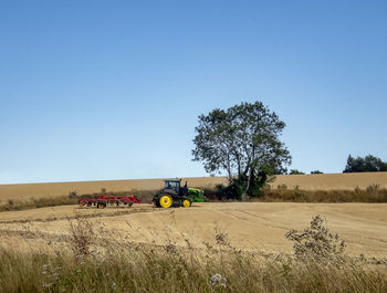 A tractor ploughing a field after the harvest in mid suffolk, england