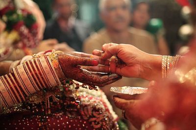 Cropped hand of mother with bride during wedding ceremony