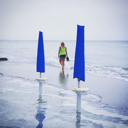 Full length of boy on beach against clear sky