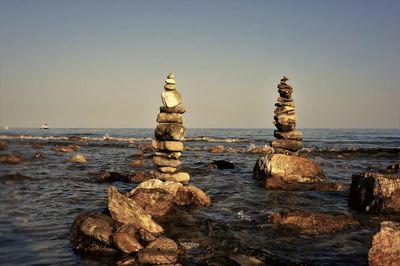 Stack of rocks on beach against clear sky