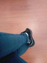 Low section of man standing on hardwood floor