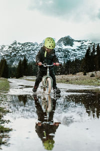 Man with umbrella on snow against sky
