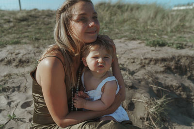 Portrait of a girl with mother sitting on land