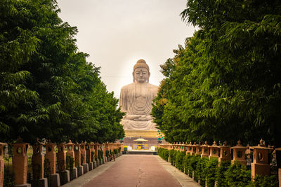 Statue amidst trees against sky