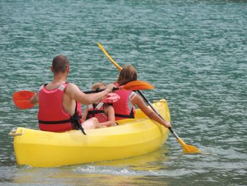 Boys sitting on boat sailing in lake