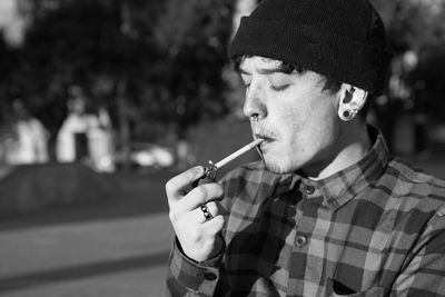 Portrait of young man smoking cigarette outdoors