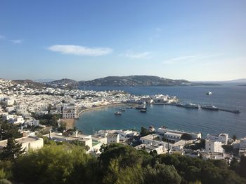 Cityscape by sea against sky