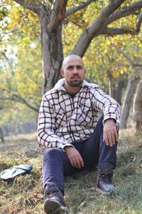 Portrait of young man sitting on land