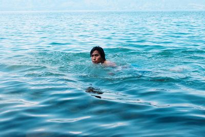 Portrait of young woman swimming in sea