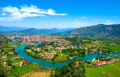 Aerial view of townscape and mountains against sky