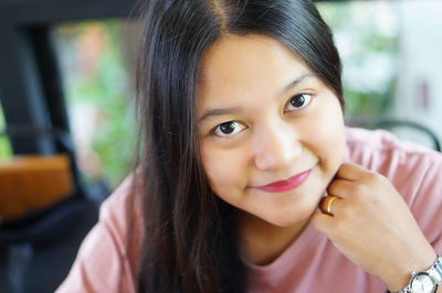 Portrait of smiling woman with hand on chin