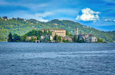 Scenic view of sea by townscape against sky