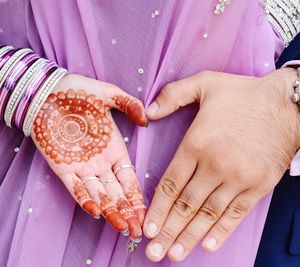 Close-up of cropped couple hands making heart shape