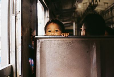 Portrait of cute boy peeking at home