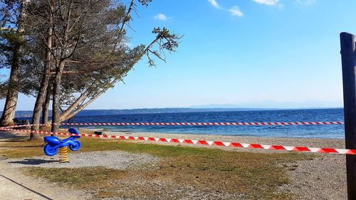 People sitting on beach by sea against sky