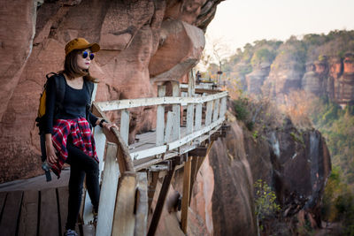 Woman standing on rock against mountain