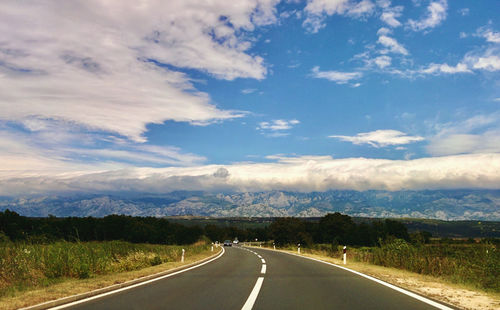 Road passing through landscape against sky