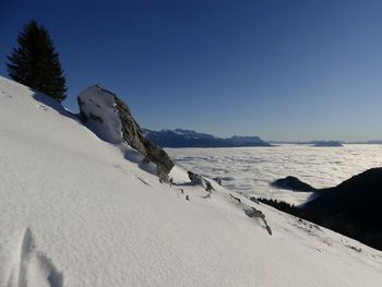 Scenic view of snowcapped mountains against clear blue sky