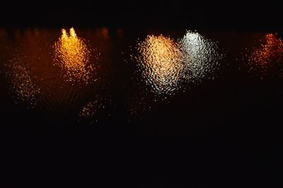 Close-up of illuminated lights against sky at night