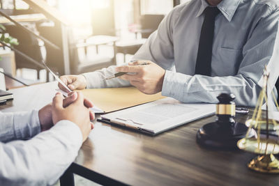 Midsection of couple holding hands on table