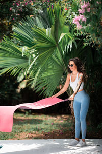 Full length portrait of young woman standing outdoors