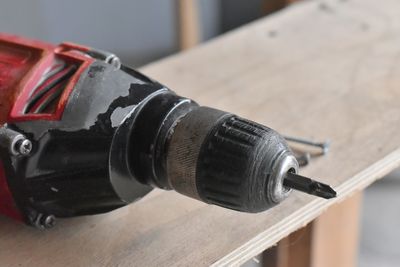 Close-up of drill on wooden table at workshop